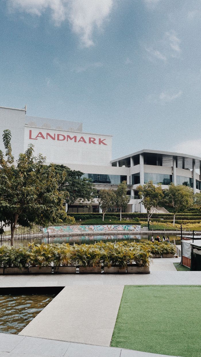 Contemporary shopping mall with lush landscaping and clear sky.